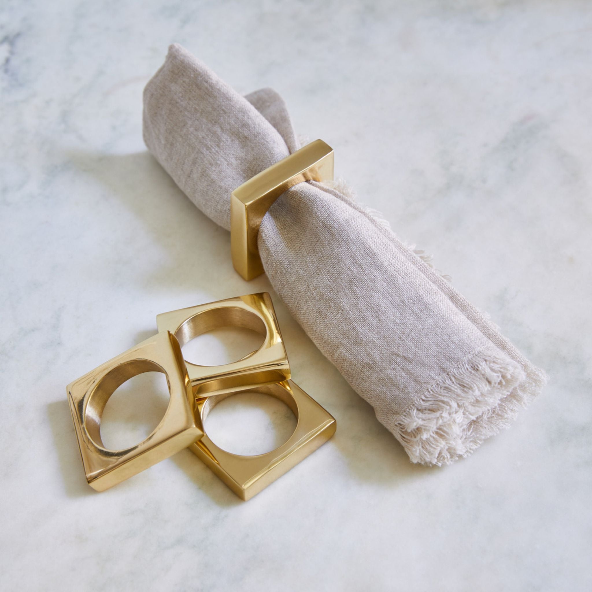 Simply Elevated - Brass Napkin Rings - A circle in a square, these weighty solid metal napkin rings embody geometric simplicity at its very best. Sold in pairs of two, they are available in either solid brass, or silver-plated brass.