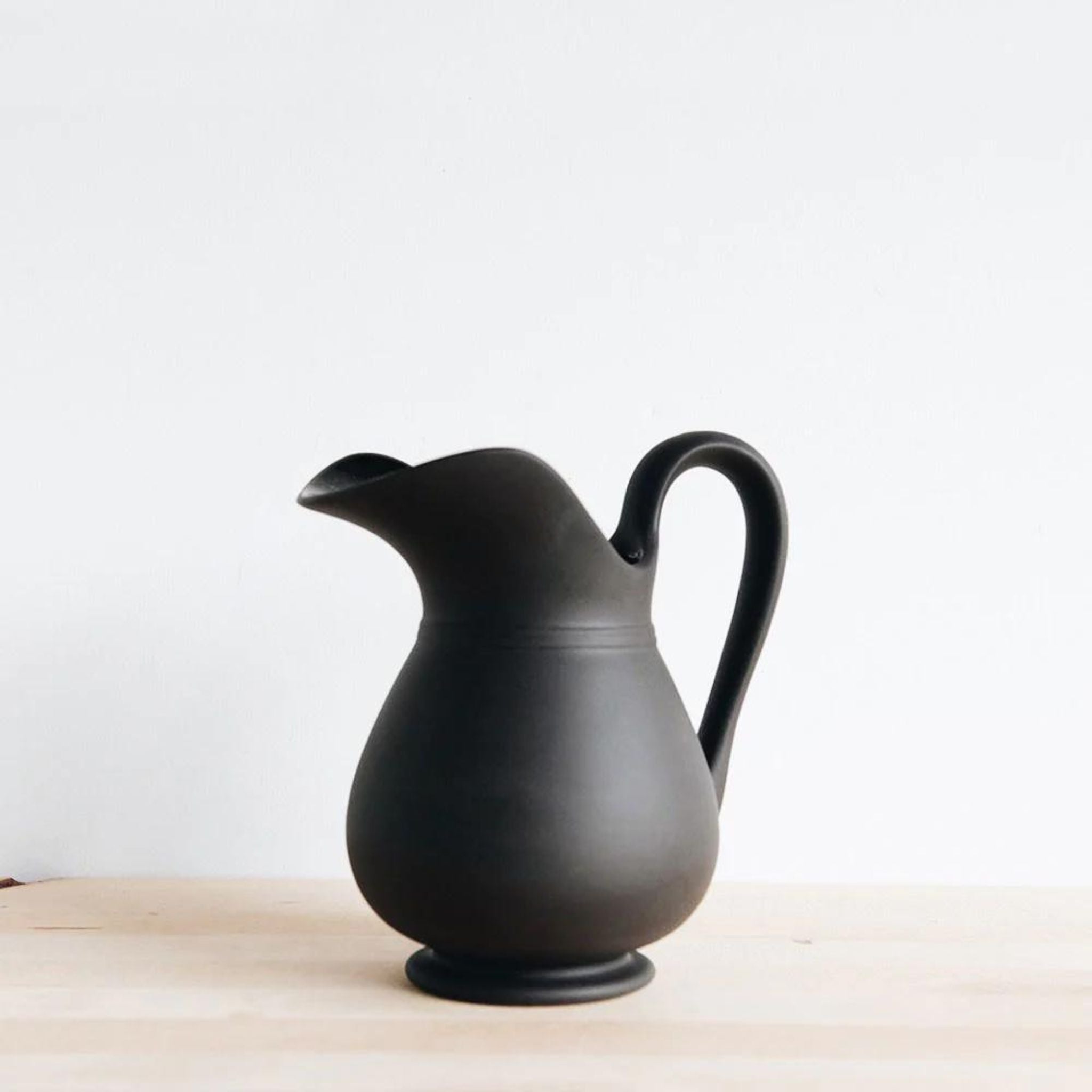 Simply Elevated - Stoneware pitcher meticulously carved by hand and then slip-cast in Sri Lanka. Available in a matte black terracotta with a shiny glazed interior. We love them for serving drinks, holding flowers, or standing proud on the mantel.