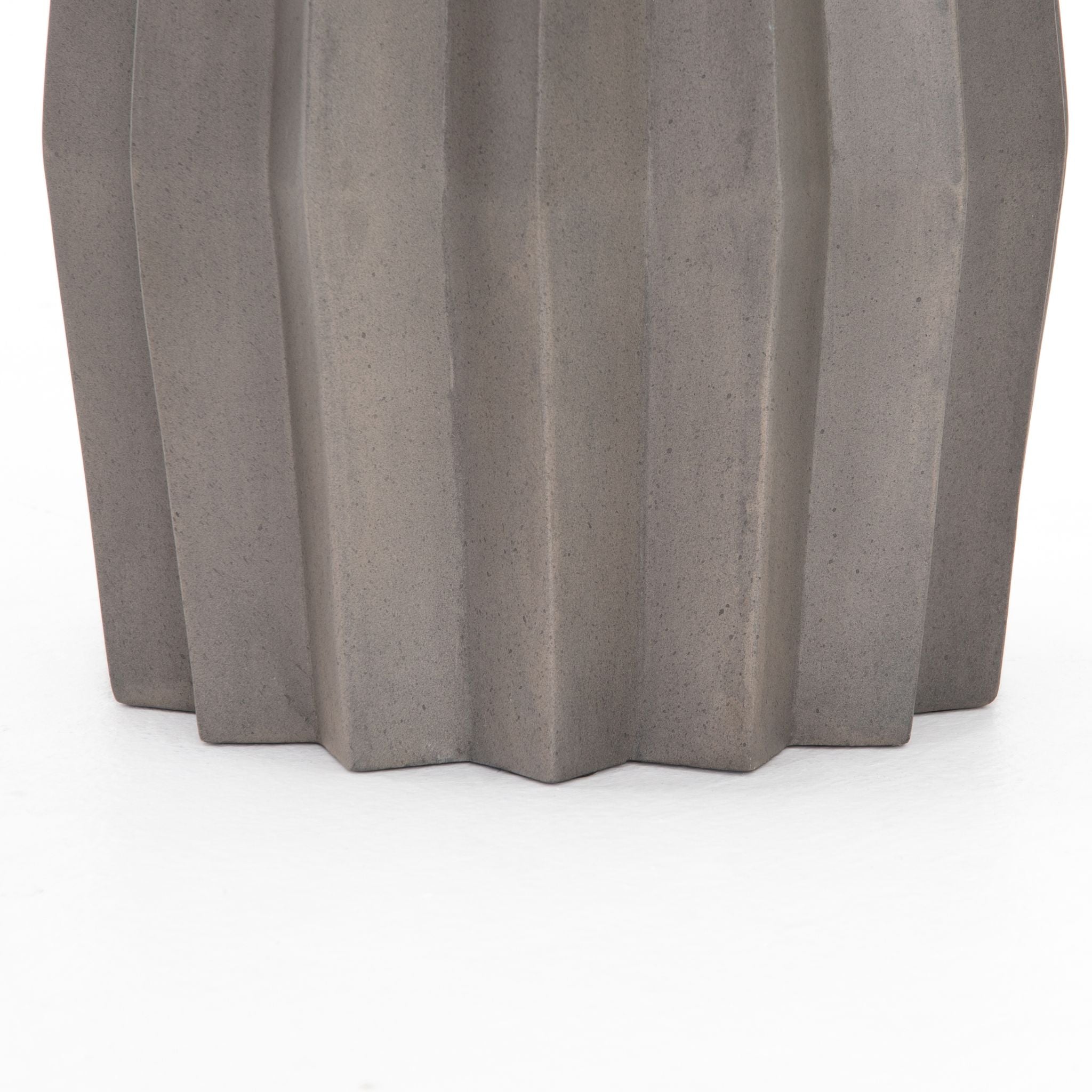 SIMPLY ELEVATED - Sculptural modern, made for outdoors. Fluted edge detailing delivers intriguing depth to solid concrete finished in an invitingly neutral dark grey. Shapely tabletop brings an extra surface to any space, indoors or out. Cover or store inside during inclement weather and when not in use.