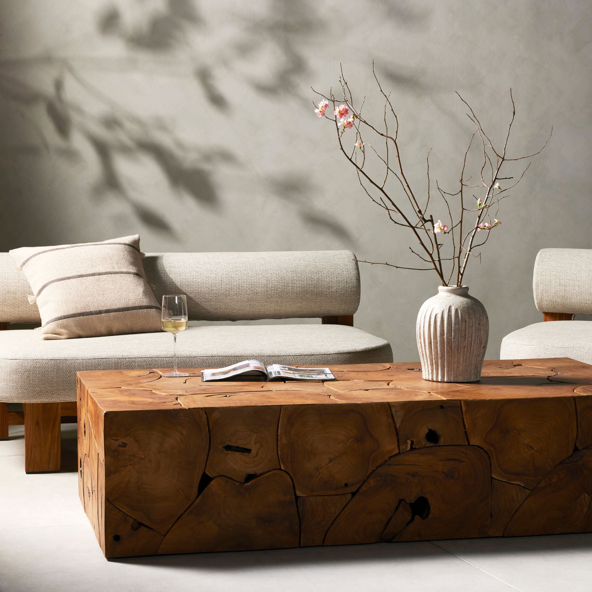 Simply Elevated - A unique layering piece — indoors or out. Made from laminated teak root with miter joinery, a simply shaped coffee table offers organic vibes and plenty of natural movement. Tables will vary from piece to piece, reflective of natural materials. Joint expansion may grow visible over time.